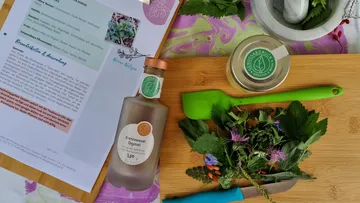 Kräuterflasche, frische Kräuter auf dem Schneidebrett.