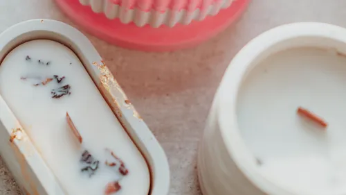 Scented candles on a beige surface.