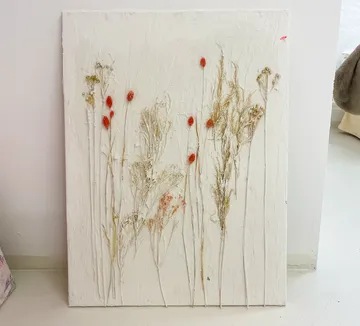 Pressed flowers on textured white canvas.