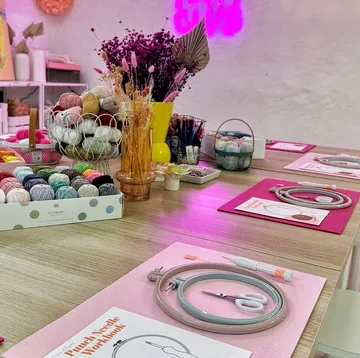 Colorful yarn and embroidery supplies on wooden table.