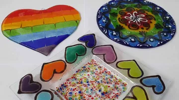 Colorful fused glass heart and plates with designs.