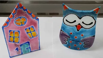 Colorful ceramic house and owl figurines.
