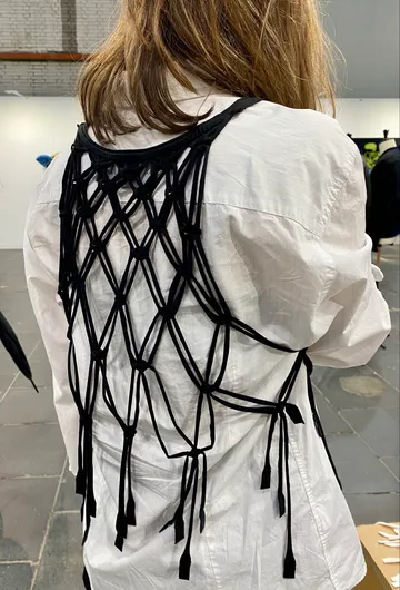 Black curly top on white shirt in gallery.