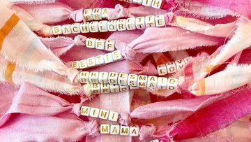 Pink fabric bracelets with letter beads and text.