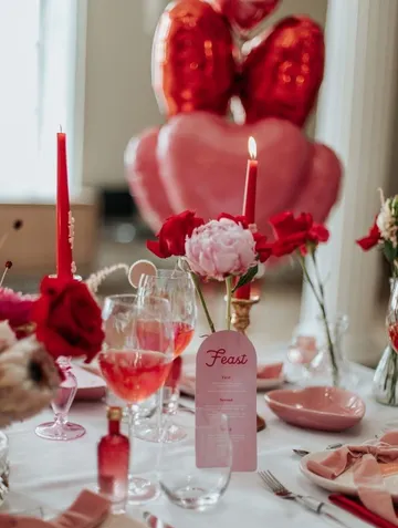 Elegante Tischdekoration mit Rosen und Kerzen.