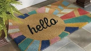 Colorful doormat with 'hello' text and geometric design.