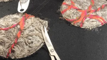 Colorful fabric circles sewn, scissors resting nearby.