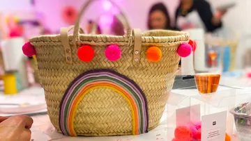 Woven basket with rainbow and pom-poms.