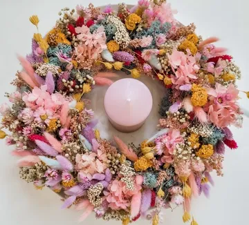 Floral wreath encircles a pink candle.
