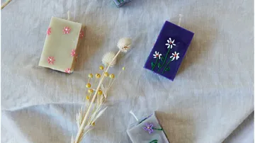 Decorative floral candles on fabric background