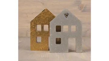 Two decorative house figurines on wood surface.