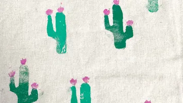 Grüne Kakteen mit rosa Blüten auf Stoff.