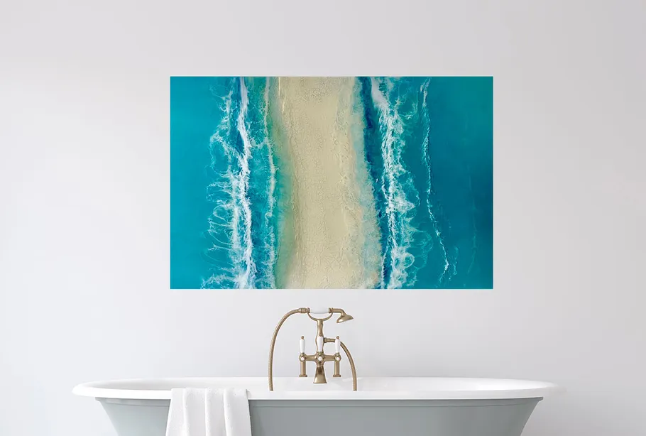 Bathtub with towel under ocean wave art.