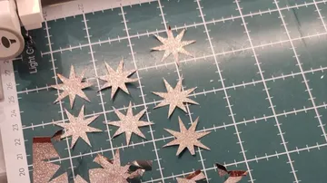 Glitzernde Sterne, geschnitten aus Papier auf gerasterter Matte.