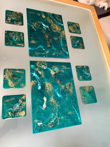 Kunstgegenstände aus blaublauem und goldenem Harz auf dem Tisch.