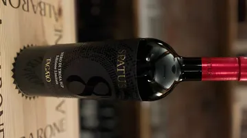 Spatus wine bottle on wooden surface.