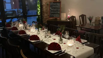 Elegant restaurant table with candles, glasses, and red napkins.
