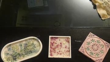 Decorative trays with floral designs on table.