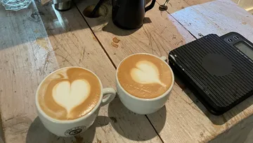 Zwei Latte mit Herz-Latte Art auf dem Tisch.