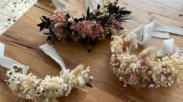 Three floral crowns on wooden table.