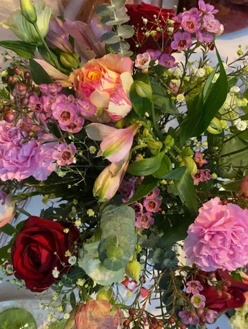 Bouquet with roses, carnations, and greenery.