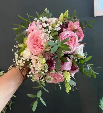 Hand holding a vibrant floral bouquet.