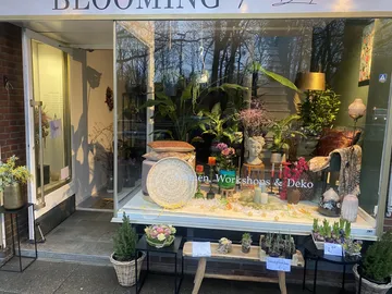 Storefront with plants and decorative items.