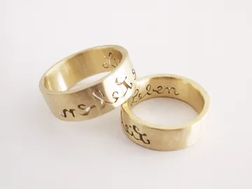 Two golden rings stand side by side on a white background.