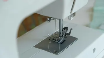 Close-up of sewing machine needle threading mechanism.