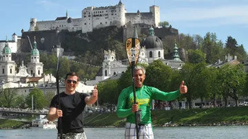 Zwei Männer mit Paddeln, Daumen hoch in der Nähe des Salzburger Schlosses.