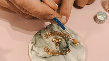 Handbemalung von Gold auf Marmoruntersetzer