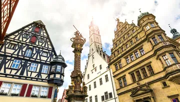 Historic German buildings with intricate architecture against a cloudy sky.