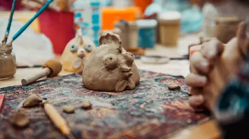Tonskulptur auf dem Tisch mit Kunstwerkzeugen.