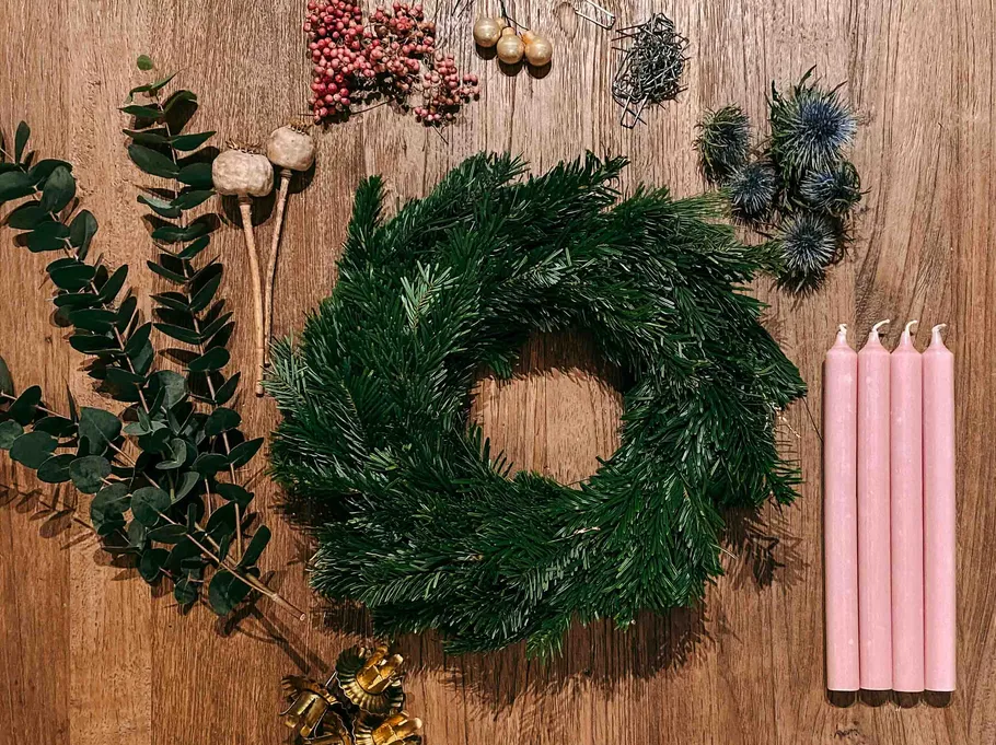 Wreath making supplies on wooden table.
