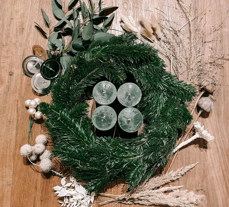 Weihnachtskranz mit Kerzen und viel Grün.