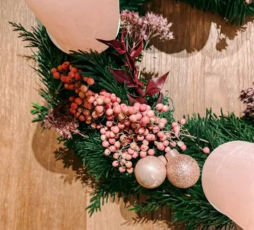 Festlicher Kranz mit rosa Kerzen und Beeren