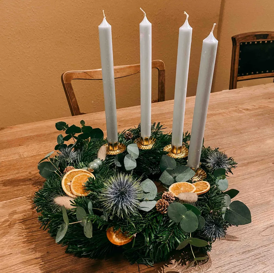 Adventskranz mit Kerzen auf dem Tisch.