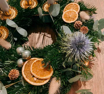 Festive wreath with dried oranges and pine cones.