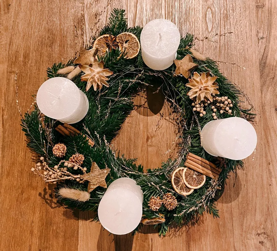 Holiday wreath with candles and dried oranges.