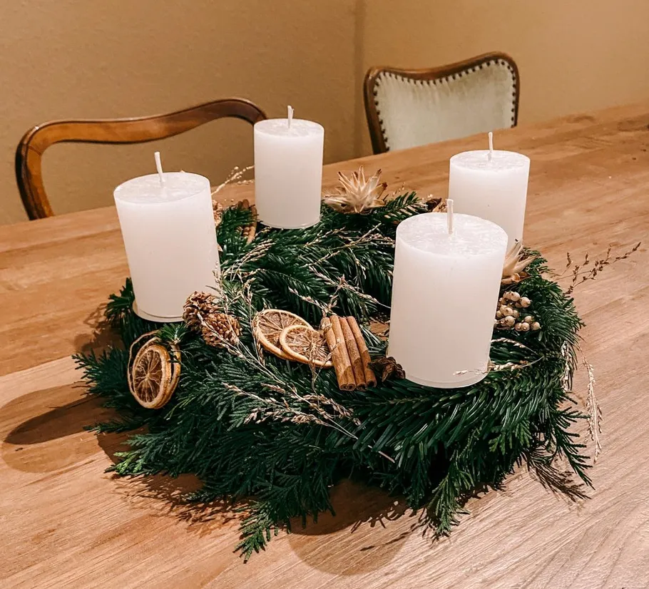 Four white candles on festive wreath.
