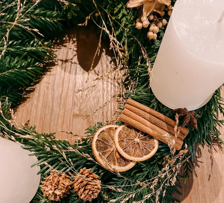 Christmas wreath with candles, dried oranges, and cinnamon.