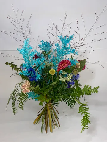 Vibrant bouquet with blue, pink, and green flowers.