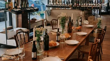Dining table with wine bottles and bread, restaurant setting.