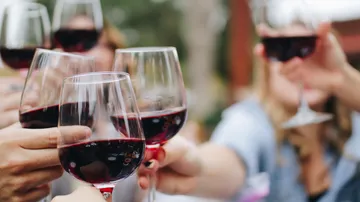Gläser Rotwein werden draußen geklirrt.