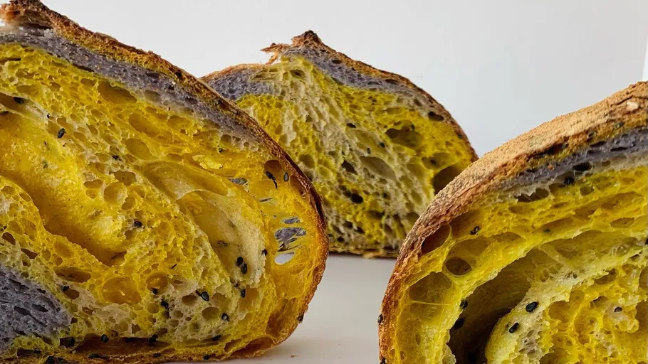 Sliced sourdough bread with colorful interior.