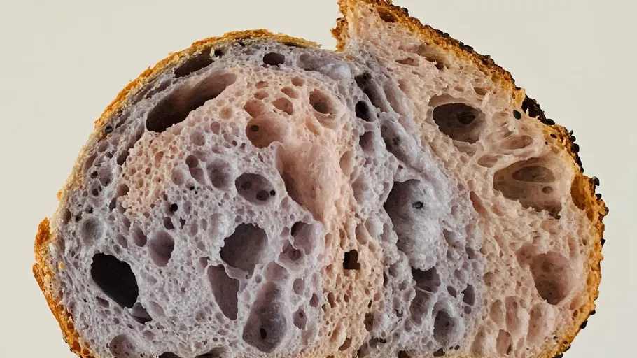 Close-up of sliced purple and beige sourdough bread.
