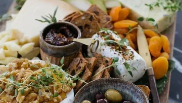 Käseplatte mit Walnüssen, Oliven und Trockenfrüchten.