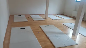 Empty yoga mats arranged in a studio.