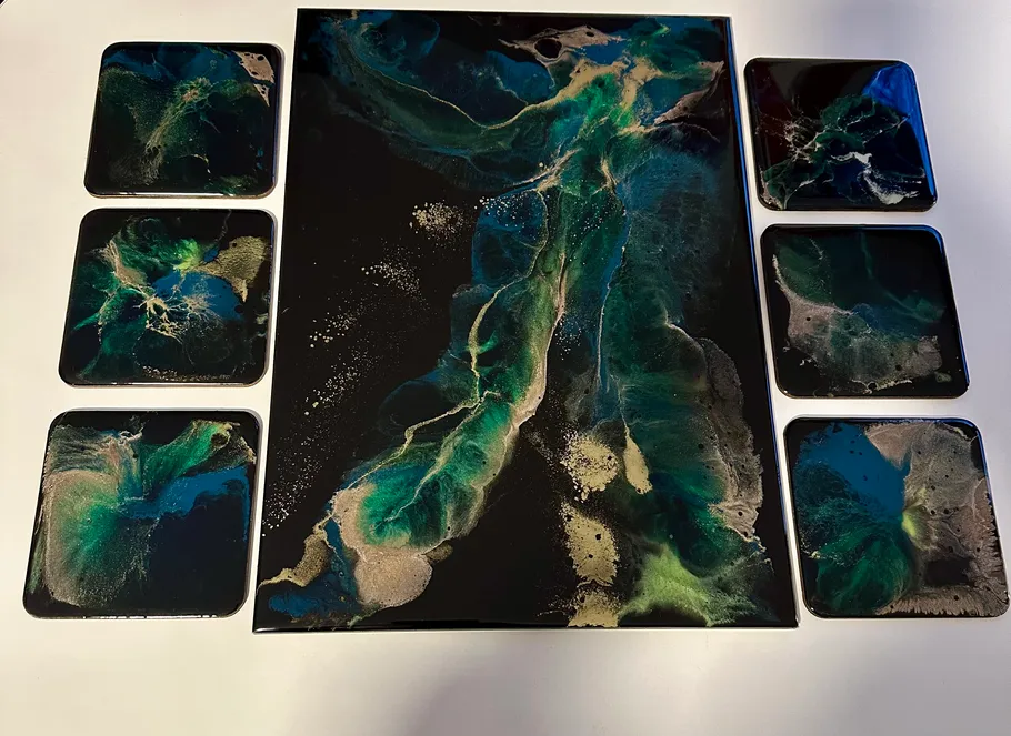 Abstract green and black resin art on coasters.
