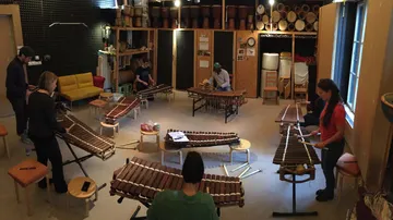 Leute spielen Xylophone in einem Musikzimmer.